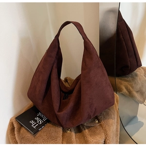 Macro shot of dark burgundy suede tote bag texture with minimalist zipper and fold details