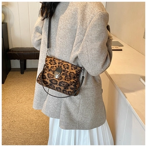 Detail showing vintage leopard print shoulder bag with metallic lock and dual straps