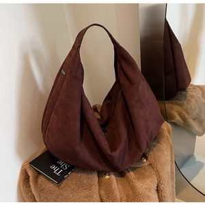 Detail of soft dark brown suede tote bag with silver rivet and matte texture finish