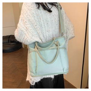 Detail of mint green canvas tote bag with adjustable strap shown in home setting