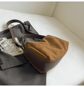 Detail shot of the vintage brown suede texture and smooth leather strap of the baguette bag
