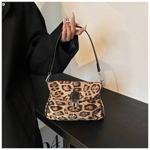 Detail of leopard print faux fur crossbody bag with silver buckle and black strap
