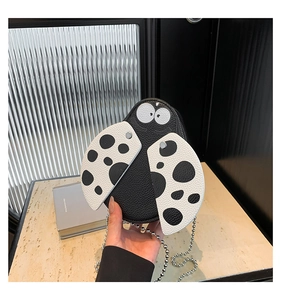 Close-up of ladybug-shaped shoulder bag in black and white lychee pattern leather