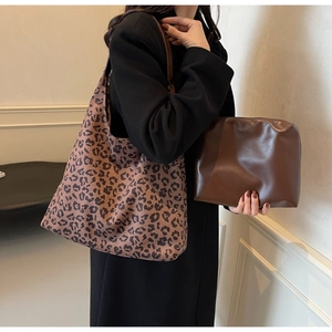 Détail du sac cabas imprimé léopard avec pochette marron porté par un mannequin