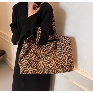 Close-up of leopard print tote bag on shoulder, showcasing canvas texture and large capacity