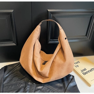 Detail of caramel suede hobo bag with wide shoulder strap and smooth metal zipper closure