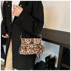 Detail shot of leopard print crossbody bag with silver buckle and thin black shoulder strap