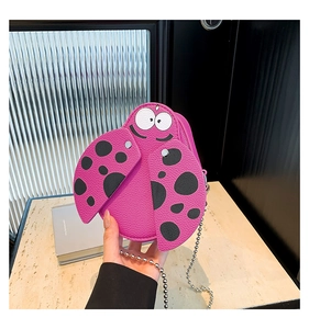 Macro view of pink ladybug-shaped mini PU crossbody bag with chain and polka dots