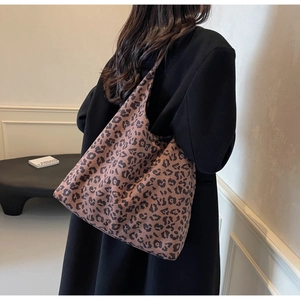 Sac fourre-tout léopard porté par un mannequin dans une pièce minimaliste à grande capacité