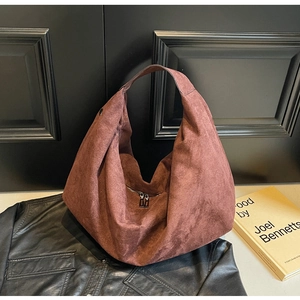 Detailed shot of large brown suede hobo bag with zip closure and wide shoulder strap