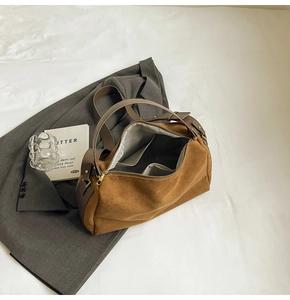 Detailed interior of vintage brown suede baguette bag with spacious lining and gold hardware