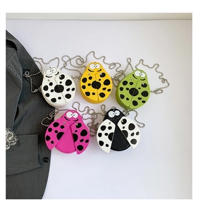 Flat lay of five mini ladybug crossbody bags in white, yellow, green, pink, and black