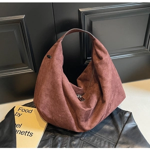 Detail of reddish brown suede hobo bag featuring large capacity and smooth top zipper