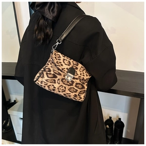 Detail of vintage leopard print crossbody bag with silver twist lock on model's shoulder