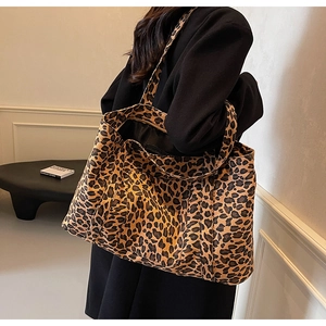 Close-up of the large leopard print tote bag showing the side view and shoulder strap