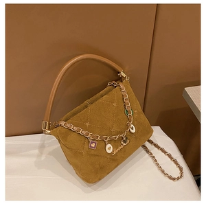 Detailed close-up of quilted velvet handbag featuring star embroidery and luxury charms