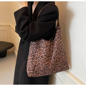 Sac fourre-tout à motif léopard avec bandoulière en cuir porté sur un long manteau en laine noir