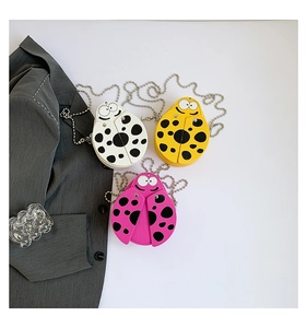 Detail of ladybug-themed mini crossbody bags in white, yellow, and pink colors