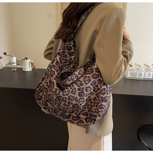 Detailed view of wide shoulder strap on a large leopard print canvas tote shoulder bag