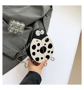 Detailed macro view of ladybug PU crossbody bag with black dots and silver chain