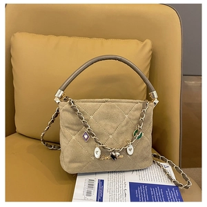 Detailed close-up of a khaki suede handbag with diamond stitching and star embroidery detail
