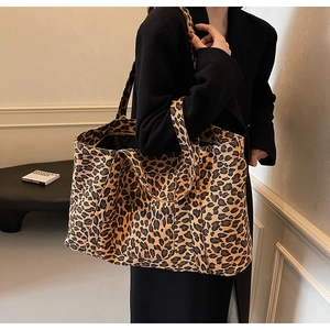 Detail shot of large leopard print tote bag in textured canvas on model shoulder