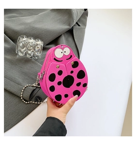 Detail of pink ladybug crossbody bag with litchi grain texture and silver ball chain