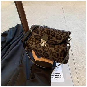 Detailed macro view of retro leopard print handbag featuring a silver metal buckle closure