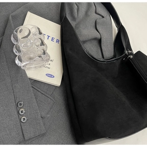 Détail du sac cabas en suédine noire avec finitions cuir et poche zippée latérale