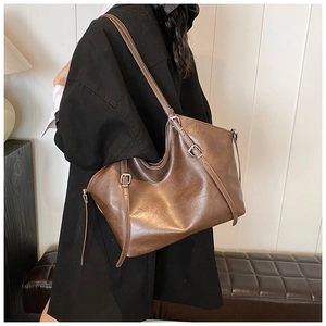 Detailed side view showing brown leather tote bag with silver buckle on a model
