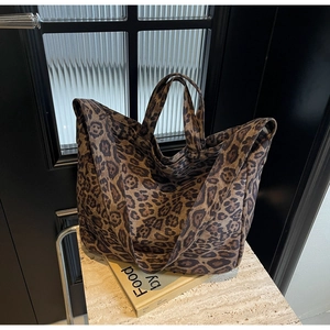 Detail of large leopard print tote bag with soft canvas texture and sturdy dual handles