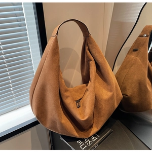 Detail view of large brown suede hobo bag with smooth zipper and wide shoulder strap