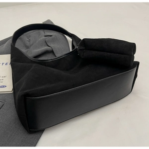 Détail du sac hobo en daim noir avec pochette assortie et texture de cuir mat premium