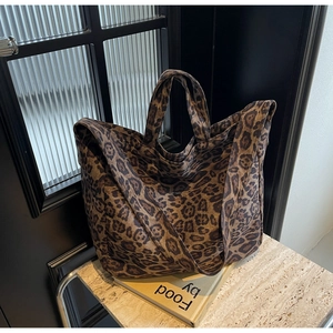 Detail shot of a large leopard print tote bag on a marble surface for travel