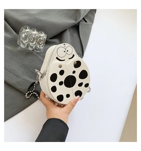 Detail shot of mini ladybug crossbody bag with white lychee grain leather and bead chain