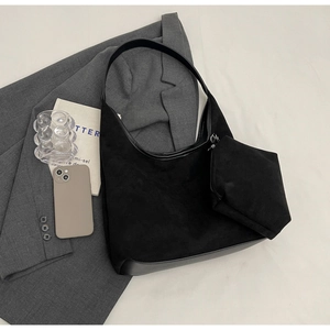Vue à plat du sac hobo en daim noir avec mini pochette assortie et accessoires