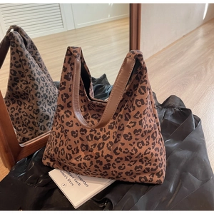 Détail du sac cabas à imprimé léopard avec anses en cuir marron et texture daim doux