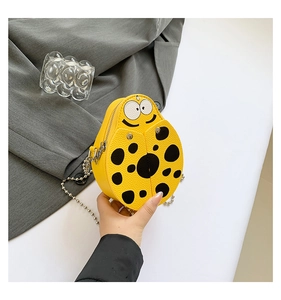 Detailed view of yellow ladybug-shaped mini crossbody bag with metal chain strap