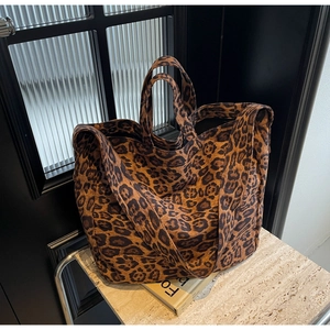 Close-up of leopard print canvas tote bag with dual handles and wide shoulder strap