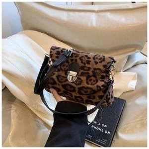 Detail of leopard print shoulder bag with silver buckle and black leather strap texture