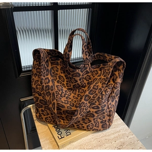 Detailed close-up of leopard print canvas tote bag with thick shoulder strap and sturdy handles