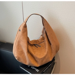 Close-up of the vintage brown suede hobo bag with a double-zipper and soft texture
