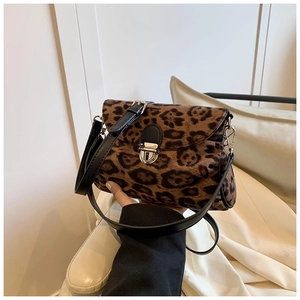 Close-up of small leopard print bag showing plush faux fur texture and black leather strap