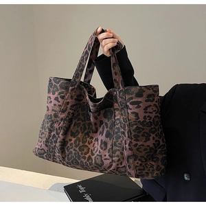 Close-up of leopard print canvas tote bag showing thick handles and durable material