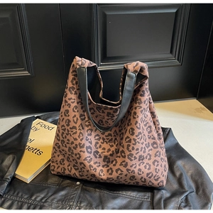 Gros plan du sac cabas en toile léopard avec des poignées en cuir noir et grande texture