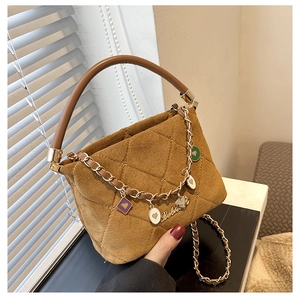 Detail shot of brown quilted suede handbag with gold chain strap and elegant charms