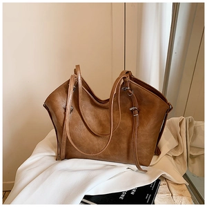 Close-up of retro brown faux leather tote bag with fine texture and adjustable strap