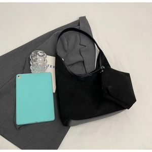 Vue de dessus d'un grand sac seau noir en daim avec pochette zippée et tablette tactile