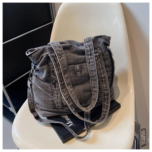 Detail view of a vintage charcoal grey denim tote bag with adjustable strap and metal hardware