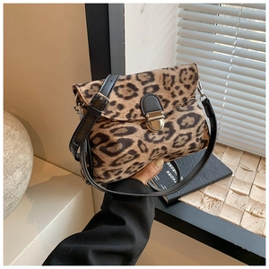 Close-up of leopard print crossbody bag with gold round lock and black leather strap